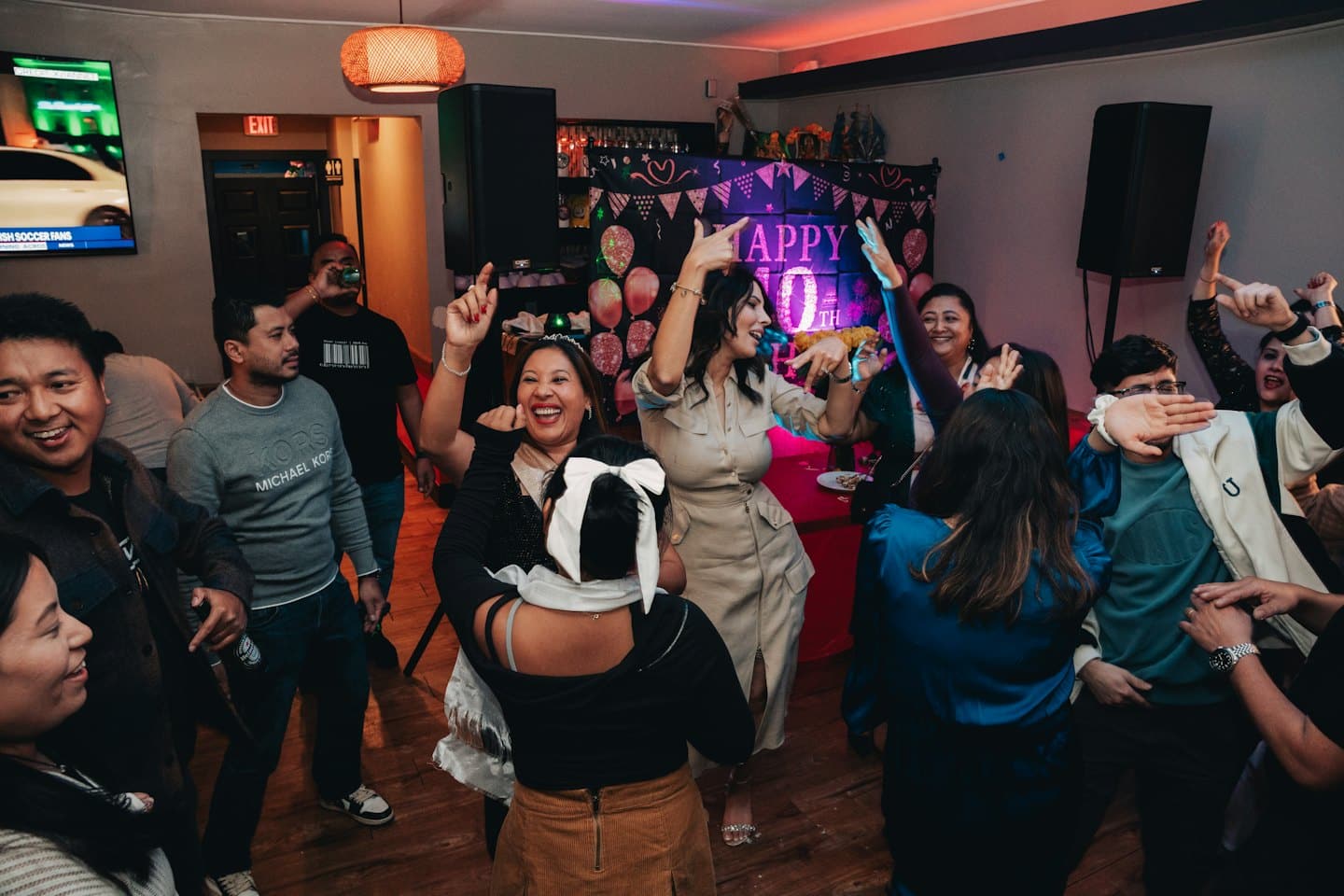 Adulti diversi che ballano e festeggiano felici a un evento al chiuso.