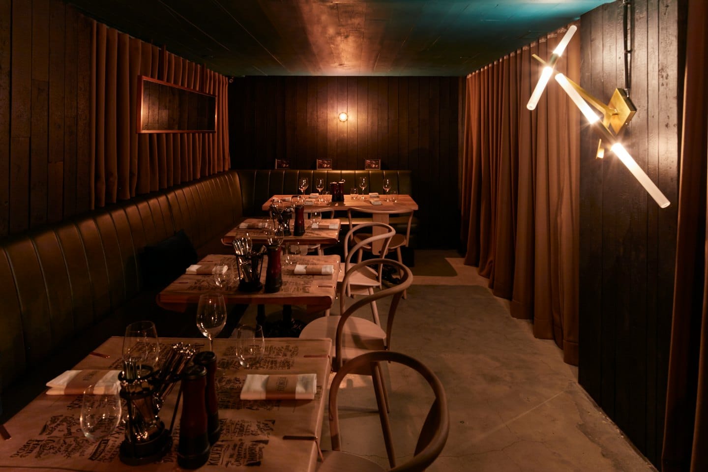 Sala da pranzo vuota di un ristorante con tavoli apparecchiati e posti a sedere in un bancone.